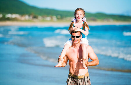 Happy father and his adorable little daughter on the beachの写真素材