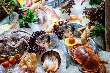 Raw Fish, crab and other seafood on iceの写真素材