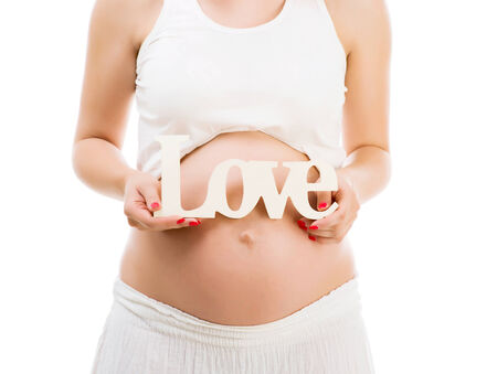 Close up of a cute pregnant belly with word love on itの写真素材