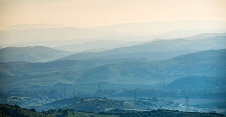 Distant mountain range and thin layer of clouds on the valleys
