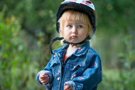 Cute little girl with sport helmet for bicycle, roller or skateの写真素材