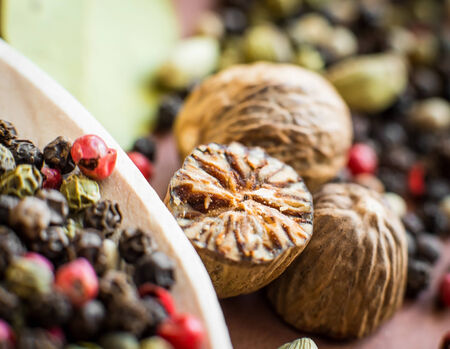 Nutmeg with broken part, peppers and other spicesの写真素材