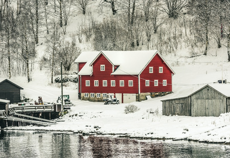wooden houses on the banks of the Norwegian fjord, beautiful mountain landscape in winter