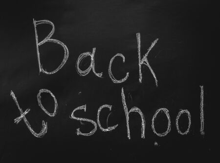 Inscription back to school in chalk on black chalkboardの写真素材