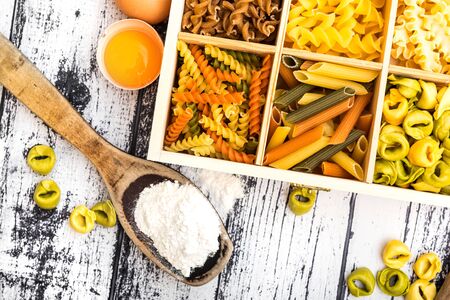 different kinds of pasta and products on textured wooden tableの写真素材