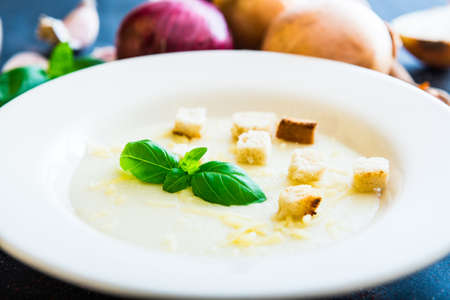 onion soup puree in a white plate with toastsの写真素材