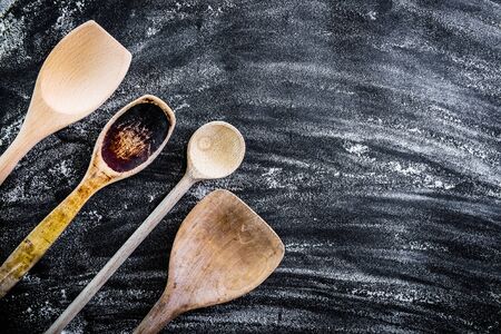 wooden spoons on a black  textured tableの写真素材