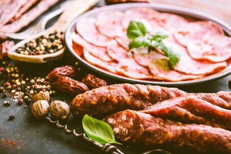 various sausages with spices on black tableの写真素材