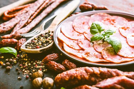 various sausages with spices on black tableの写真素材