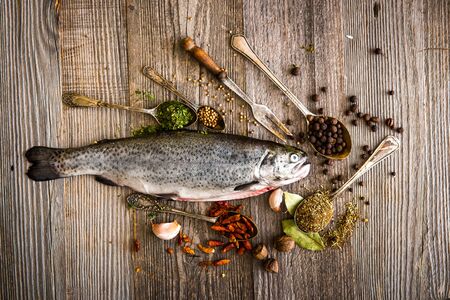 fresh trout with spices and seasonings on a dark tableの写真素材