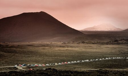 beautiful mountain landscape with a queue of cars in Timanfaya National Park in Lanzarote, Canary Islandsの写真素材