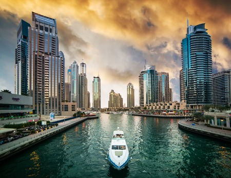 Dubai, United Arab Emirates - December 14, 2013: Modern skyscrapers and water channel with boats of Dubai Marina at sunset, United Arab Emiratesのeditorial素材