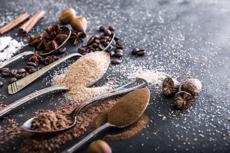 Chocolate powder cocoa and coffee spoons on the table blackの写真素材