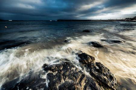 spellbinding dusk with dark blue sky at seaの写真素材