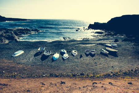 boats on a sandy stony tideの写真素材