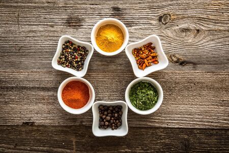aromatic colorful spices in bowls on wooden backgroundの写真素材