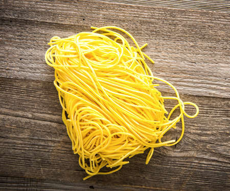 raw italian pasta on a dark wooden backgroundの写真素材