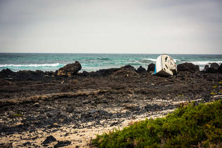white boat on a stony shore by the sea