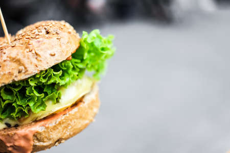 fried burger with lettuce on grey backgroundの写真素材