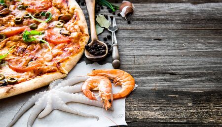 delicious pizza with seafood on wooden tableの写真素材