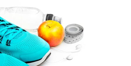sport background: blue running shoes  and apple with objects isolated on white backgroundの写真素材