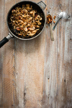 fried meat in pan on wooden table with text spaceの写真素材