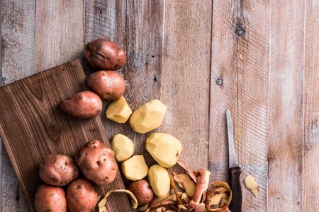 row popato on a cutting board with knifeの写真素材