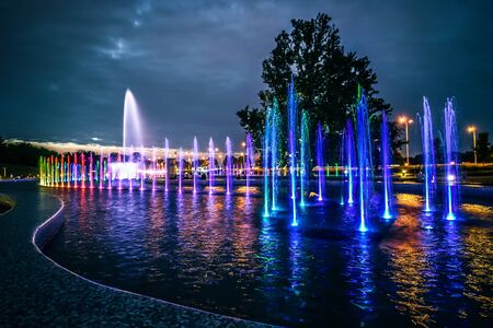 colorful illuminated musical fountain in Warsaw at duskの写真素材