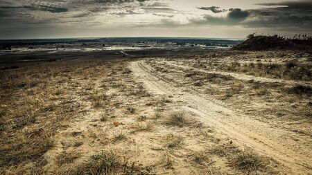scenic landscape of rolled road in a sandy fieldの写真素材