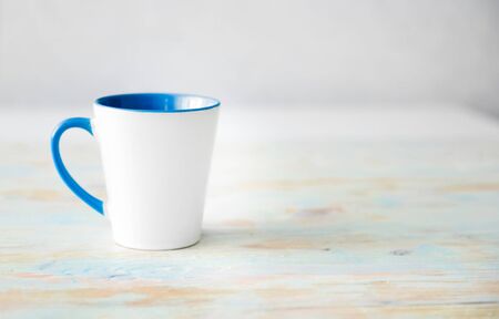 white cup with blue handle and inner surface close upの写真素材