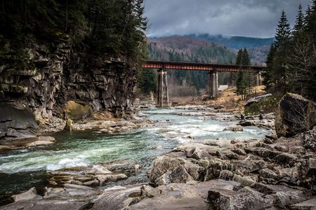 landscape in Carpathian mountains with river, railway bridgeの写真素材