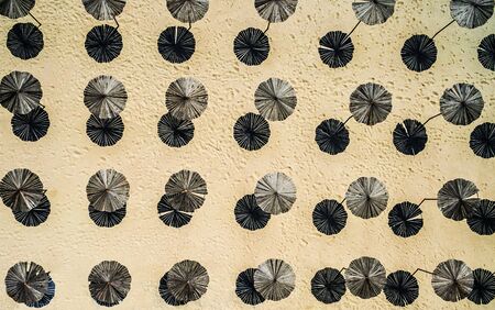 wooden sunshade umbrellas on a beach, top view, aerial photo