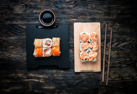 set of sushi rolls with salmon topping on wooden boardの写真素材