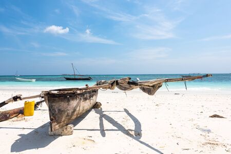 wooden canoe on the shore of Africa with ocean on the backgroundの写真素材
