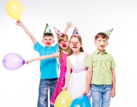 funny children with clown noses and birthday hats standing one by one