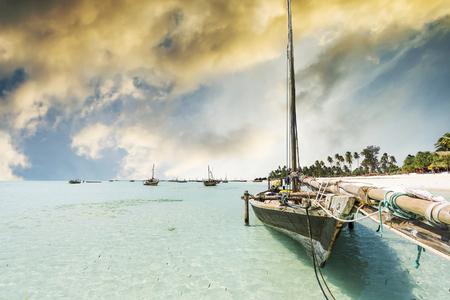 wooden boat anchored on the African shore in clear ocean water