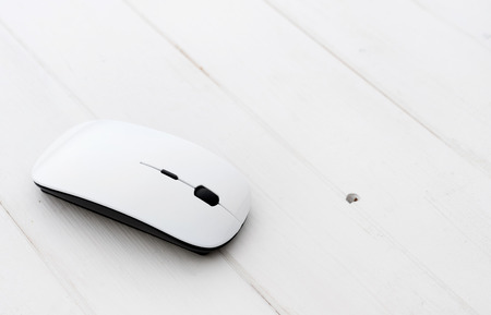White wireless mouse with pad on a wooden backgroundの写真素材