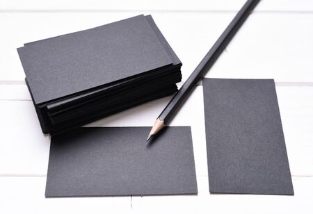 black business cards with pencil on a white table