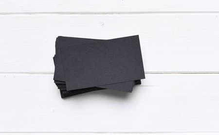 black business cards on a white wooden table, top viewの写真素材