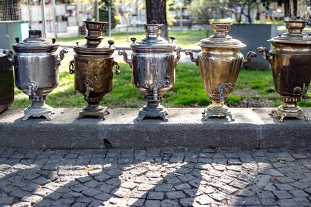 Old brass samovars sitting on the street waiting to be soldの写真素材