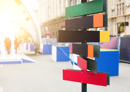 Bright, colorful road direction pointer with space for your text left, city life on backgroundの写真素材
