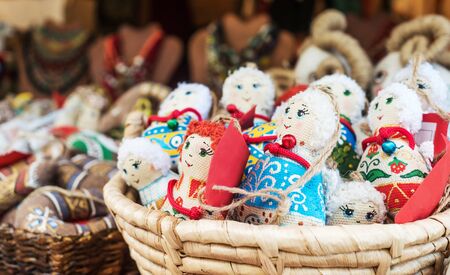 Colorful textile traditional female dolls as souvernirs sitting in basket, fair for tourists, on saleの写真素材