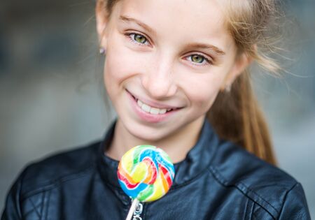 Beautiful little girl with candy, outdoor