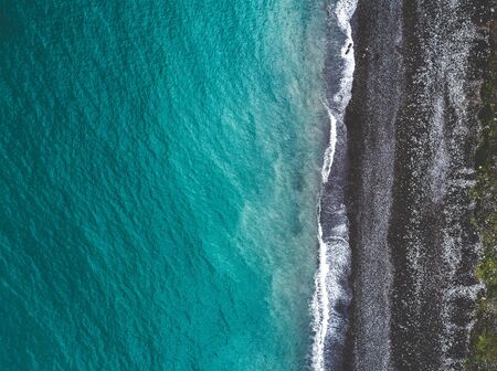 Aerial view of sea shoreline and dark pebble beach. View from above.の写真素材