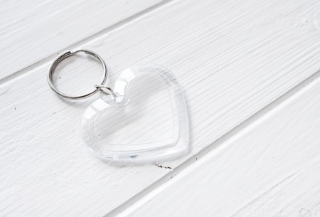 Transparent trinket in heart shape on a white wooden tableの写真素材