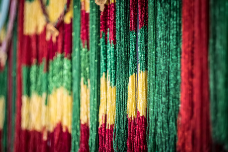 Colored strings of green, yellow and red beads on street market