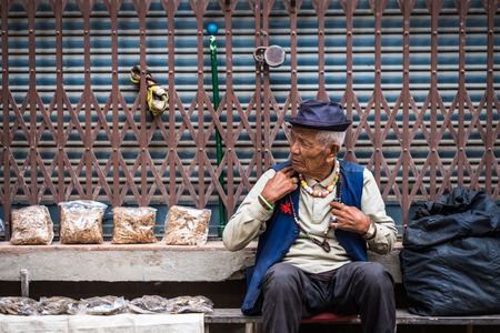 Kathmandu, Nepal - 06 October 2017: Portrait of old nepalese man in blue hat and rosaries on his neck on the street of Kathmandu, Nepalのeditorial素材