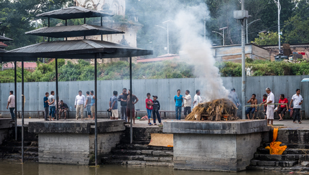 Kathmandu, Nepal - 06 October 2017: People watching cremations ceremony at the Pashupatinath temple.