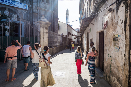 Zanzibar, Tanzania - July 14, 2016: Tourists watching architecture of Zanzibar, Tanzania and meeting local folks, facing povertyのeditorial素材