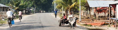 Zanzibar, Tanzania - July 14, 2016: Local folks riding in carriages with bulls, riding bicycles, walking in Zanzibarのeditorial素材